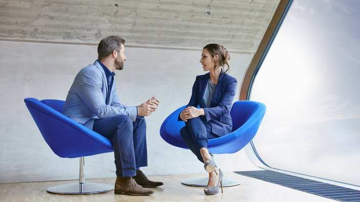 Man and woman sitting on chairs talking