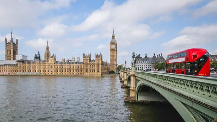 Houses of Parliament with red London bus on Westminster Bridge