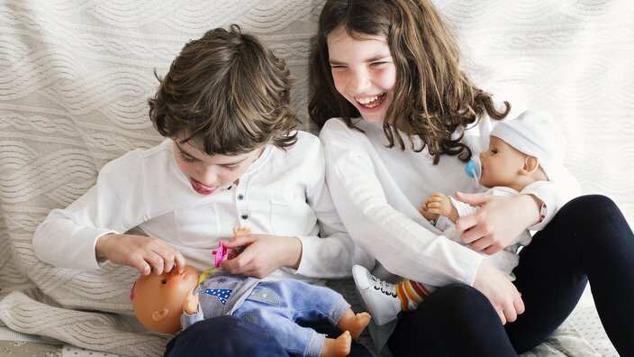 Boy and girl playing with dolls