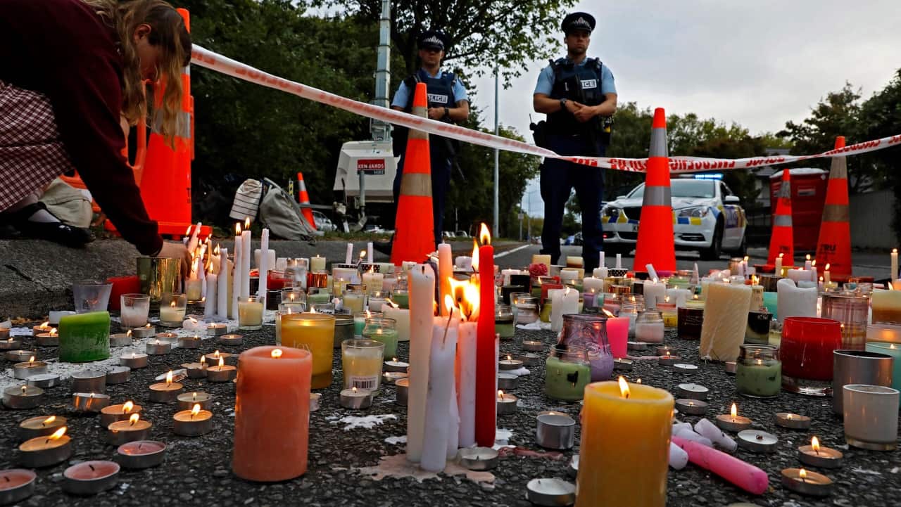 A student lights candles during a vigil to commemorate victims of the Christchurch terror attack. 