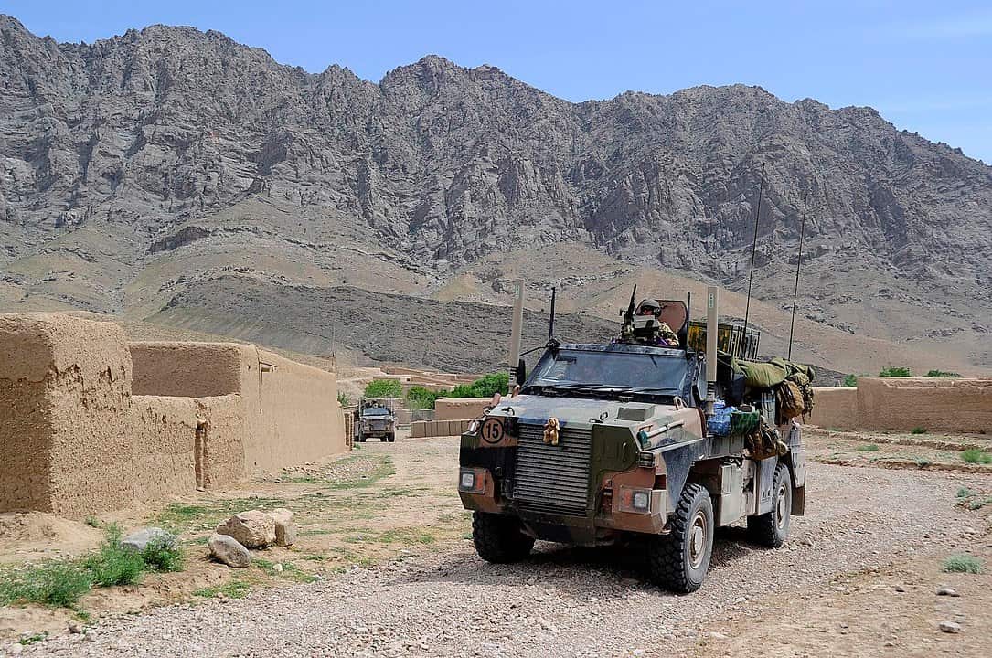 Two Bushmasters passing through a settlement in Afghanistan during April 2010