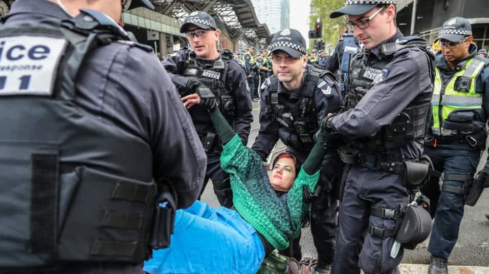 An Extinction Rebellion protester is stopped by police on Thursday.
