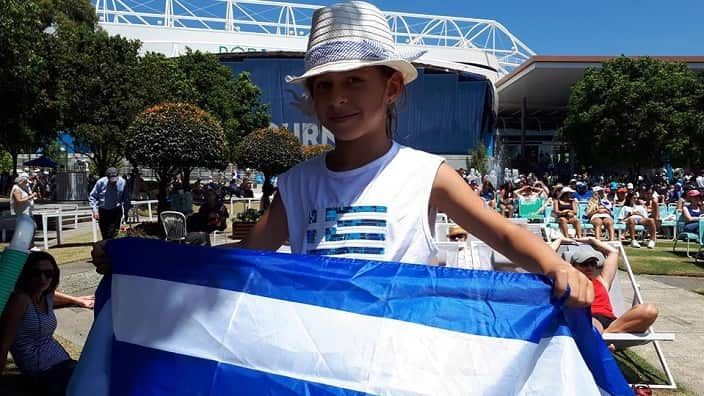 A Greek Australian girl with the Greek flag at Melbourne's Tennis Centre