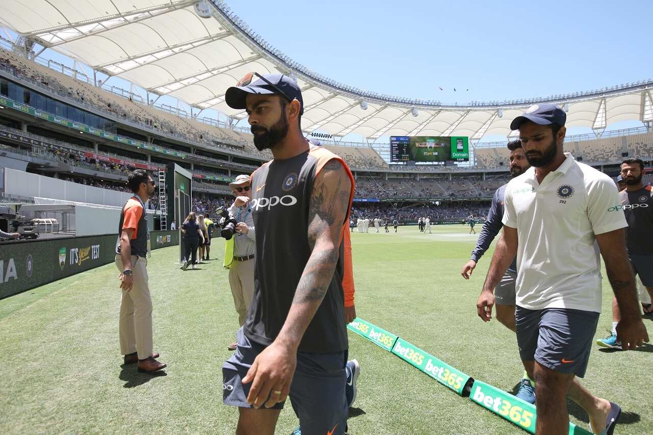 Virat Kohli (left) of India leaves the field after losing the Test on day five of the second Test match between Australia and India at Perth Stadium.