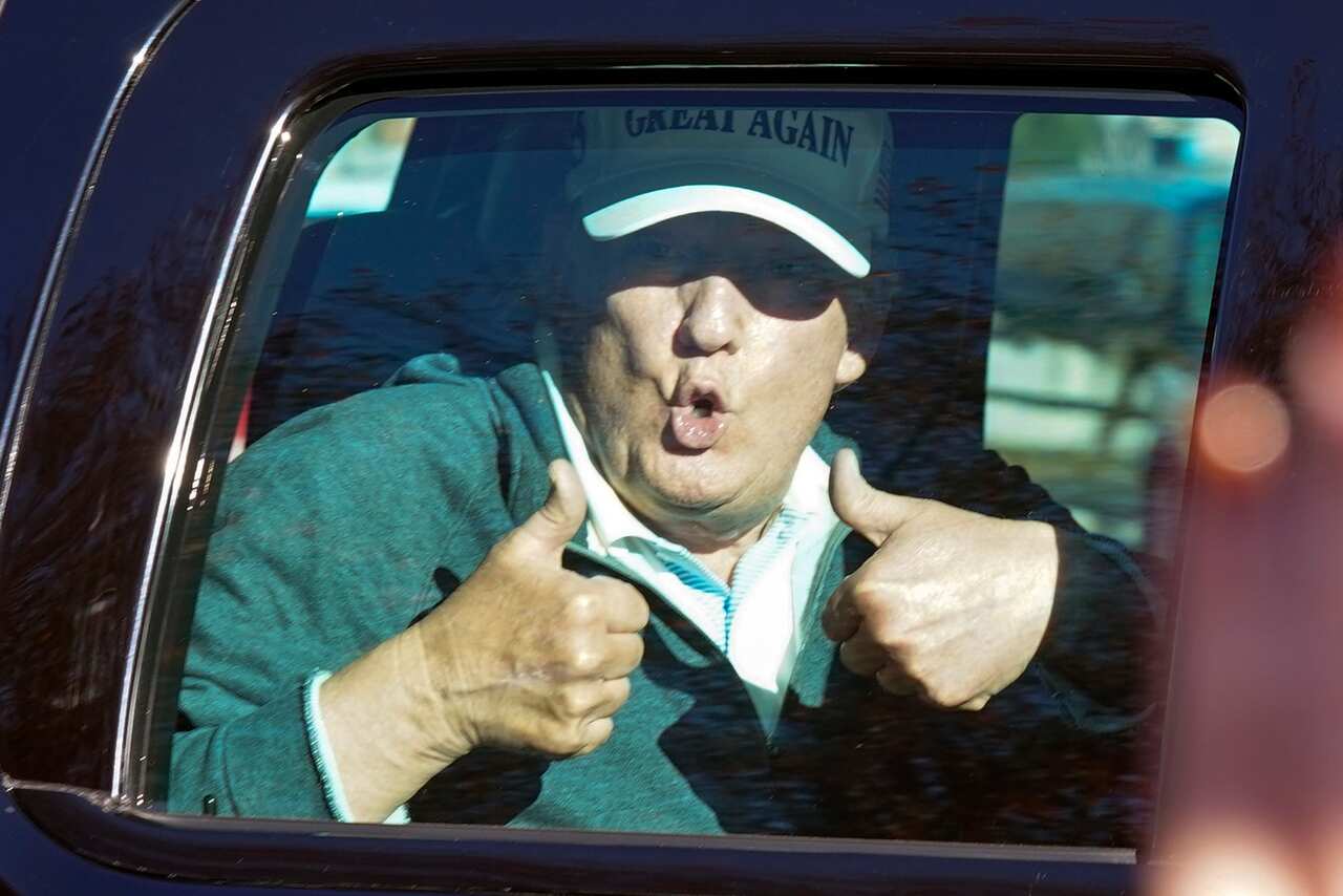 President Donald Trump gives two thumbs up to supporters his round of golf on Sunday.