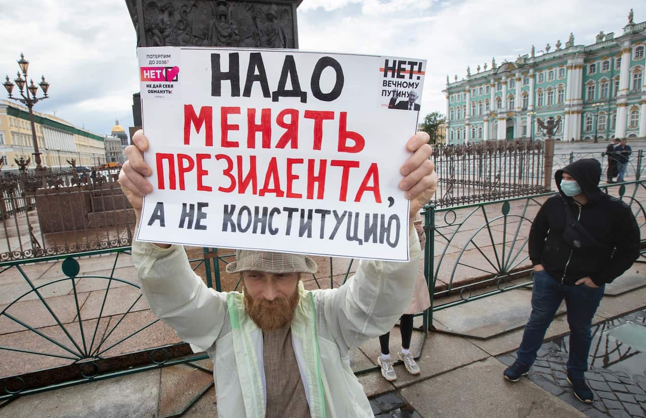 A man holds a poster reading "Need to change the president, not the constitution!" during a protest against constitutional amendments at the Palace Square in St.Petersburg