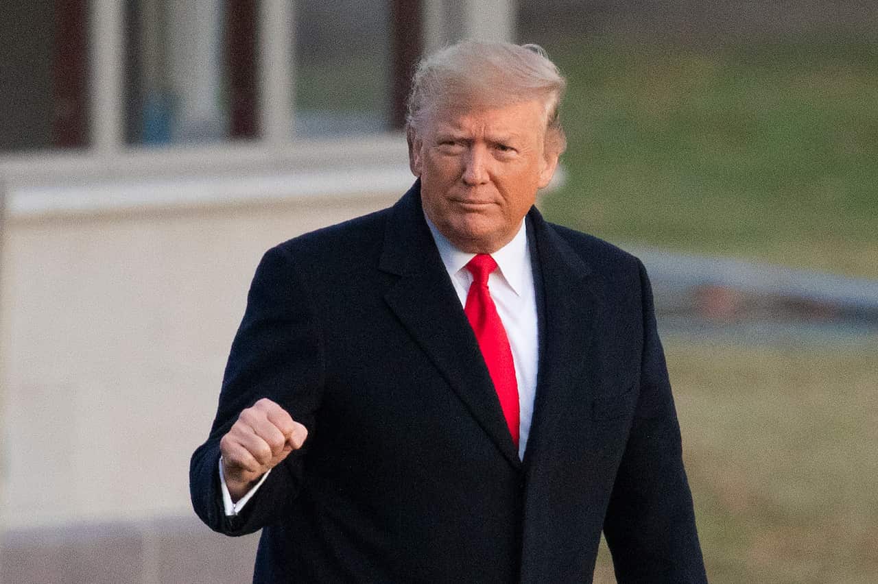 President Donald Trump pictured leaving the White House just hours before he was impeached in a historic vote.