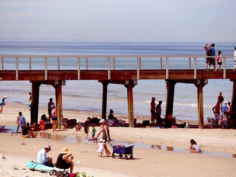 Beachgoers at Henley Beach in Adelaide seek relief from the heatwave.