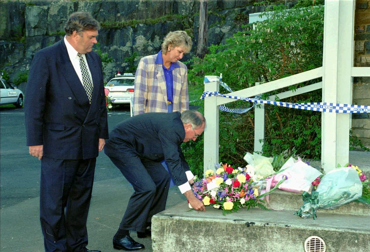 Australian Prime Minister John Howard, centre, lays flowers on the steps of the Broad Arrow Cafe