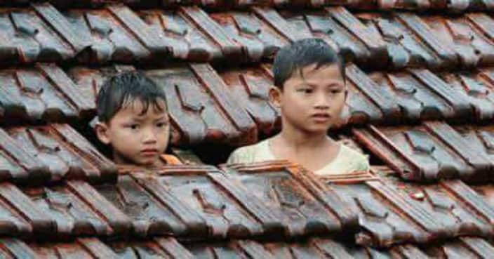 Trẻ em Quảng Bình trổ mái nhà tránh lũ.