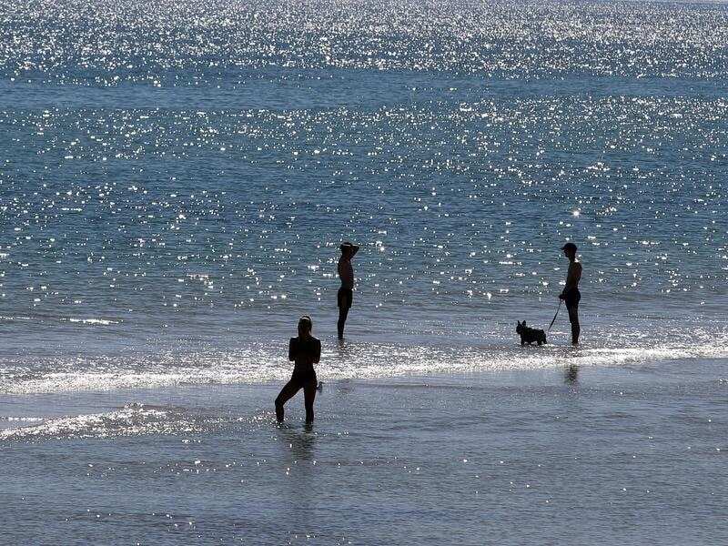 People are seen enjoying the hot weather on Henley Beach in Adelaide