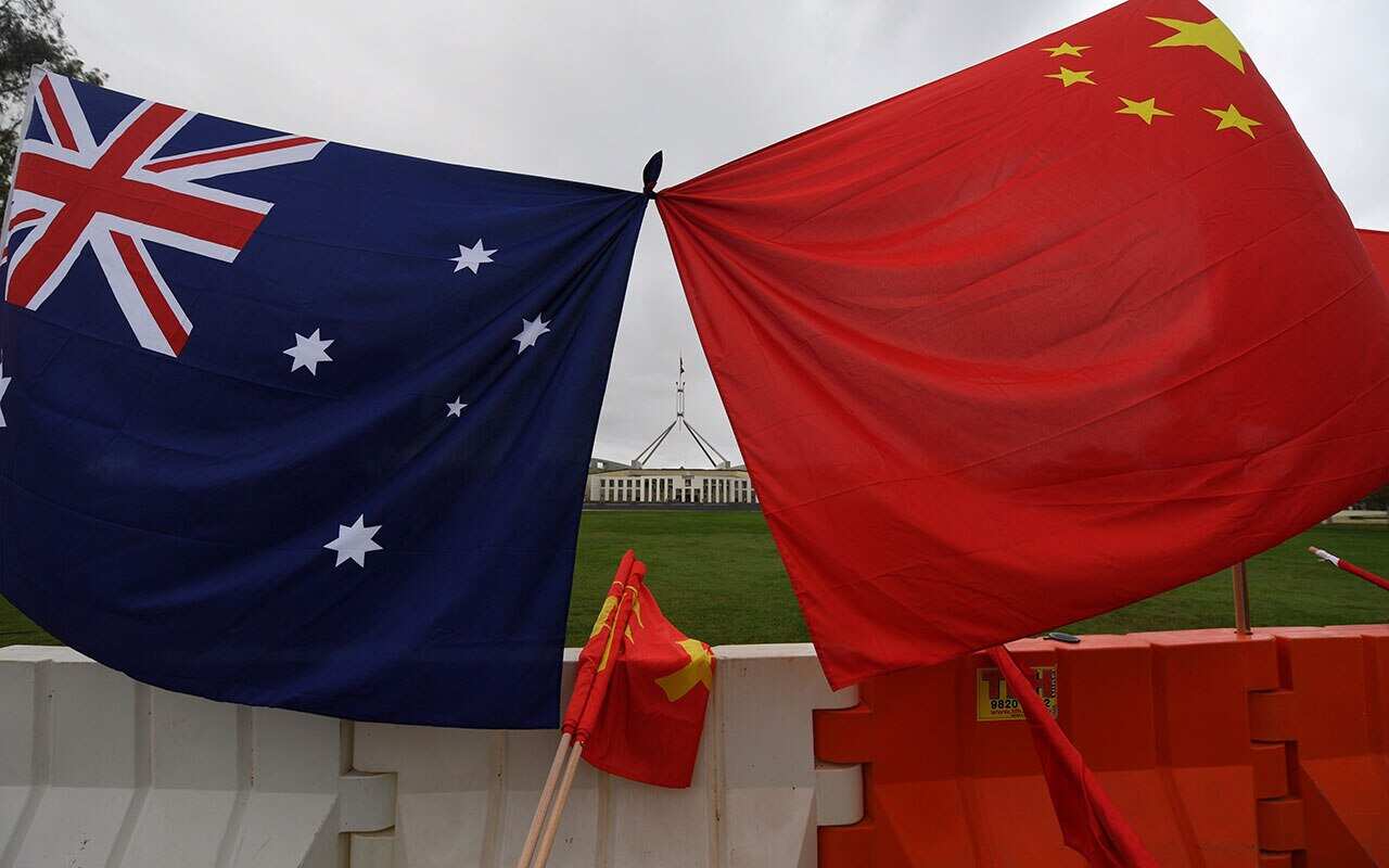 Australia's Parliament House is seen behind an Australian and a Chinese flag.
