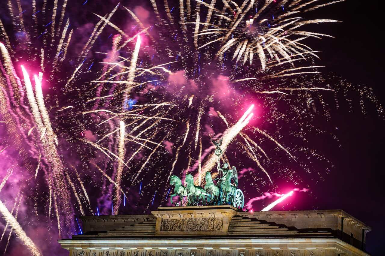 Fireworks light the sky above the Quadriga at the Brandenburg Gate during New Year celebrations in Berlin, Germany.