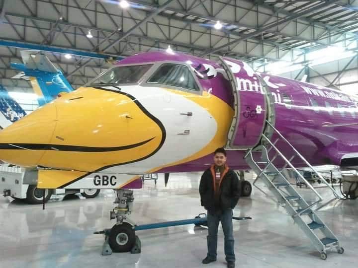 Image of Karn Sri-ampai next to a commercial airliner