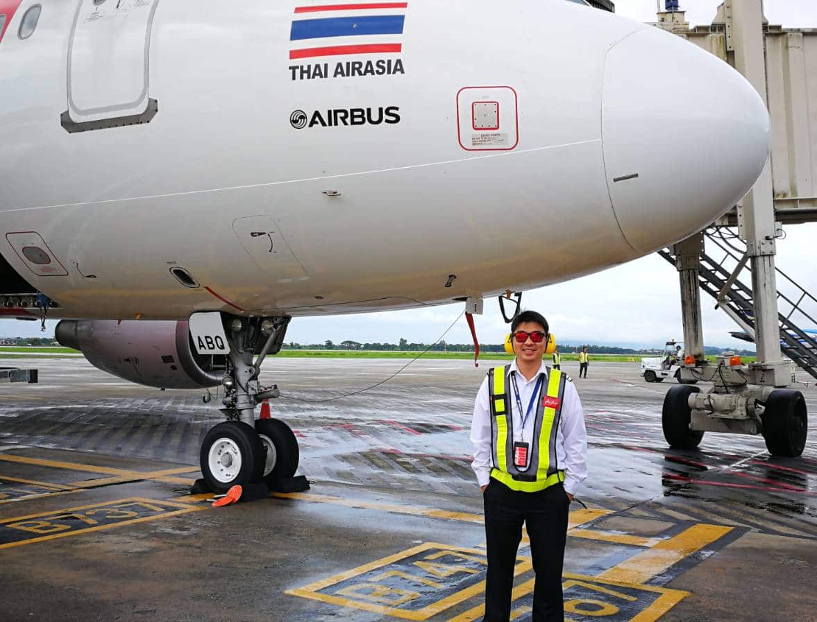 Image of Karn Sri-ampai next to an Airbus airliner