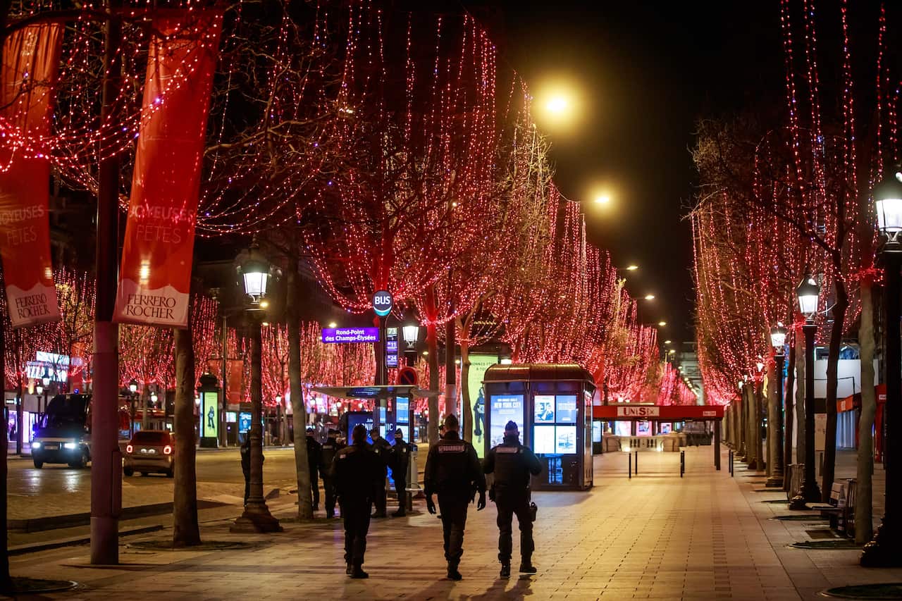 French police forces patrol the Champs-Elysees during New Year eve, in Paris amid security measures to restrain celebrations due to COVID-19.
