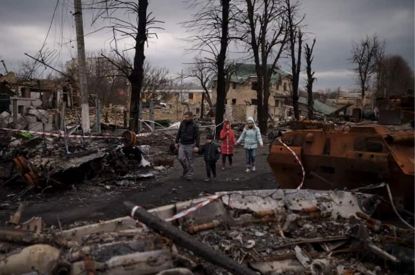 A family walks amid destroyed Russian tanks in Bucha, on the outskirts of Kyiv, Ukraine, 6 April 2022. 