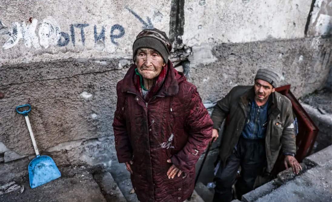 Local residents are seen in a street in the city of Mariupol.