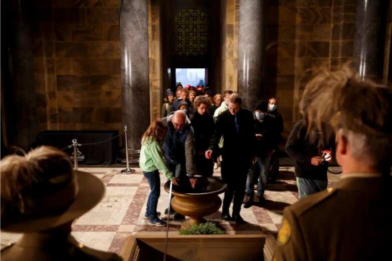 People are seen in the Sanctuary at the Shrine of Remembrance placing poppies during Anzac Day in Melbourne, Monday, 25 April, 2022.
