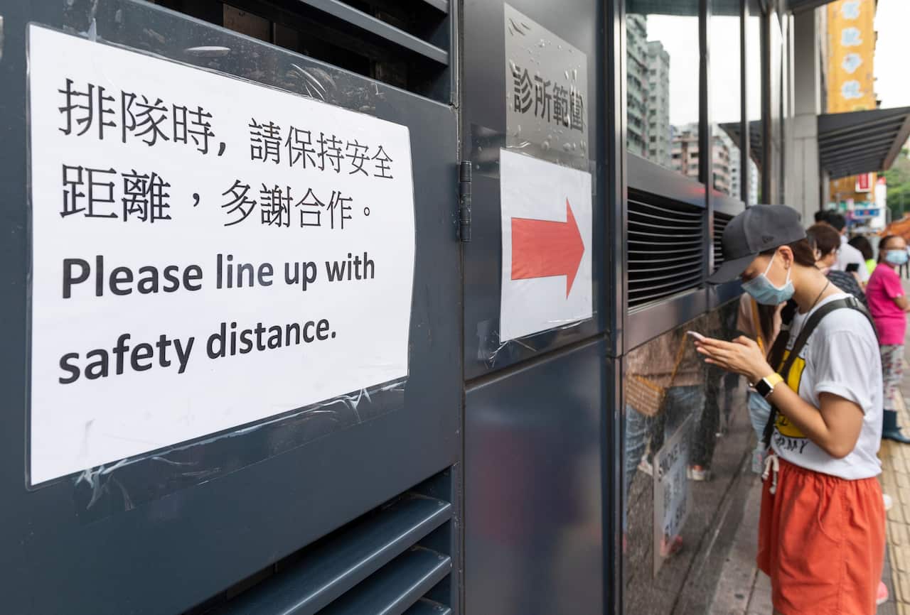 Residents queue to receive free COVID-19 test kits (AAP)