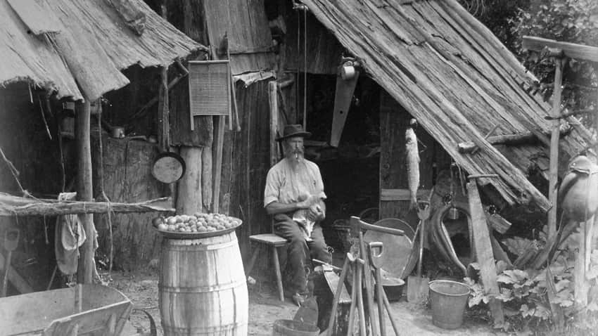 Prospector sits in front of his prospectors hut in the gold rush in Australia.