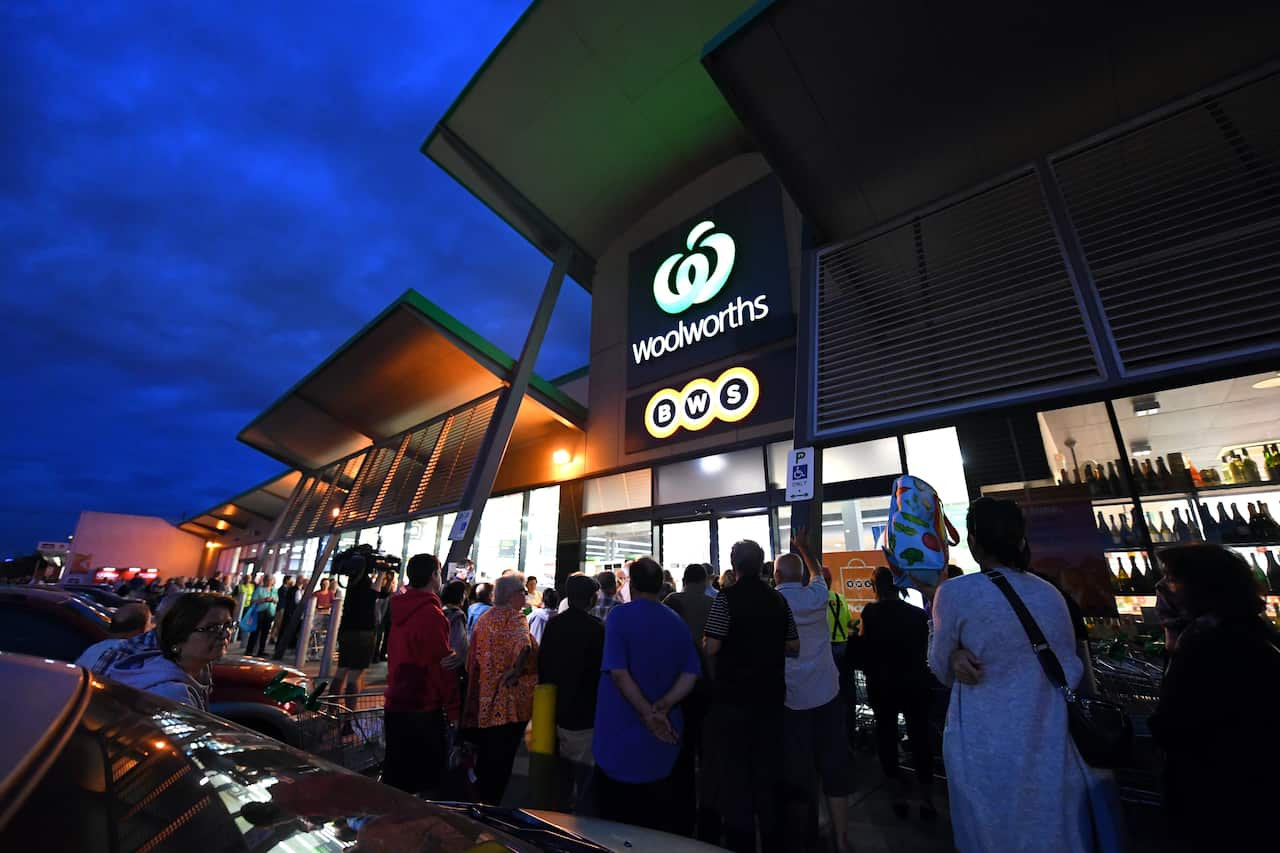 People are seen waiting outside a Woolworths supermarket in Melbourne
