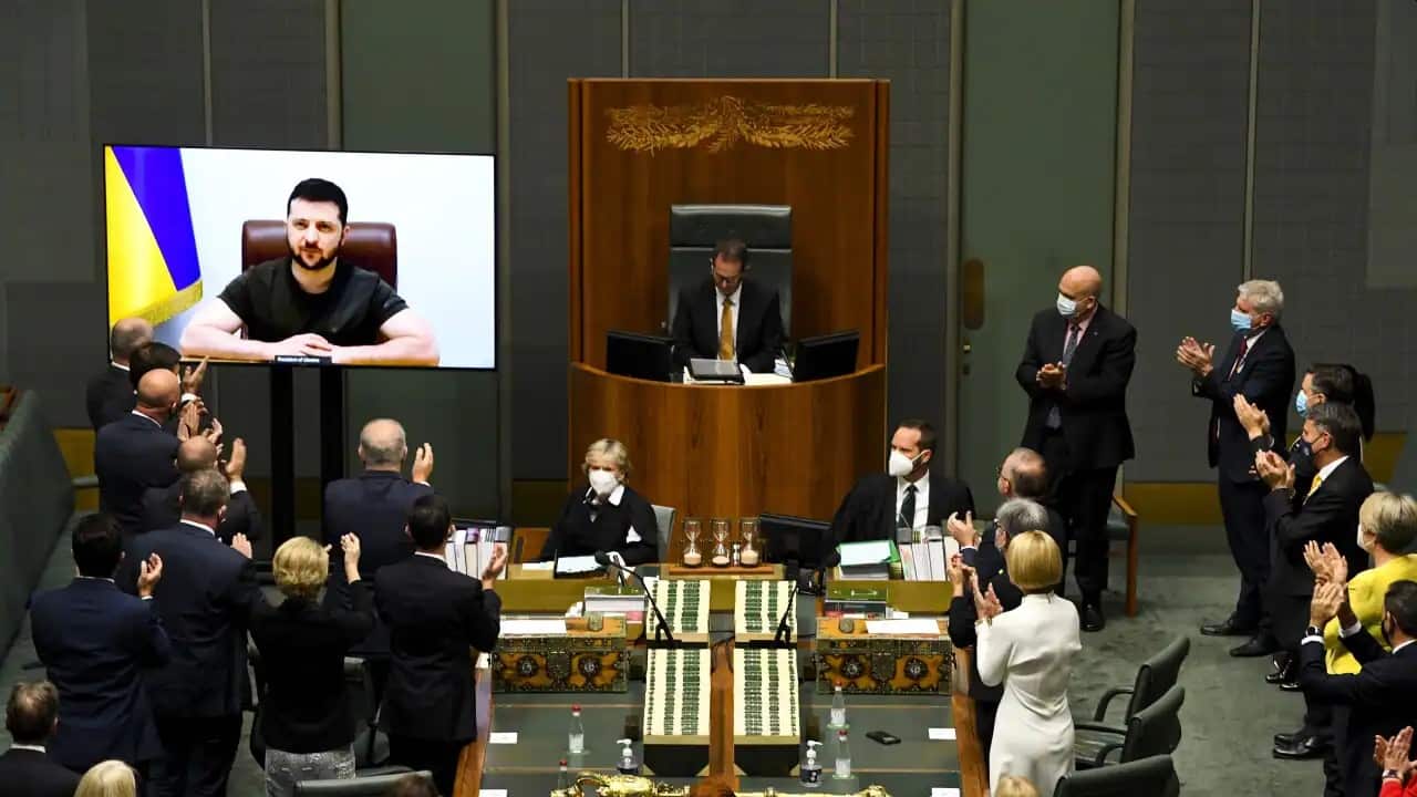 Australian members of Parliament applaude as Ukrainian President Volodymyr Zelenskiy addresses the House of Representatives via a video link at Parliament House in Canberra, Thursday, March 31, 2022.
