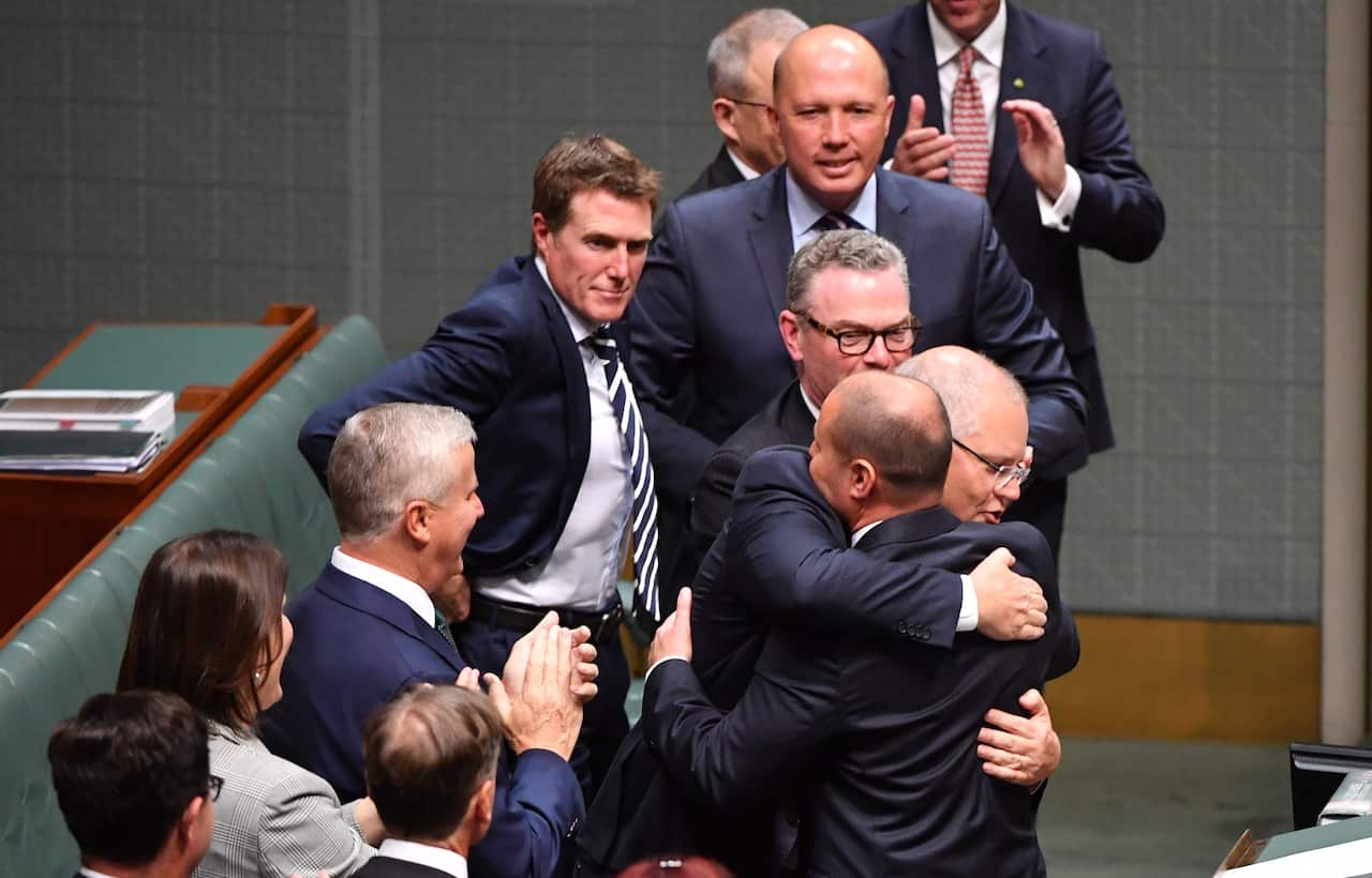 Prime Minister Scott Morrison hugs Treasurer Josh Frydenberg after handing down his first Federal Budget in the House of Representatives 