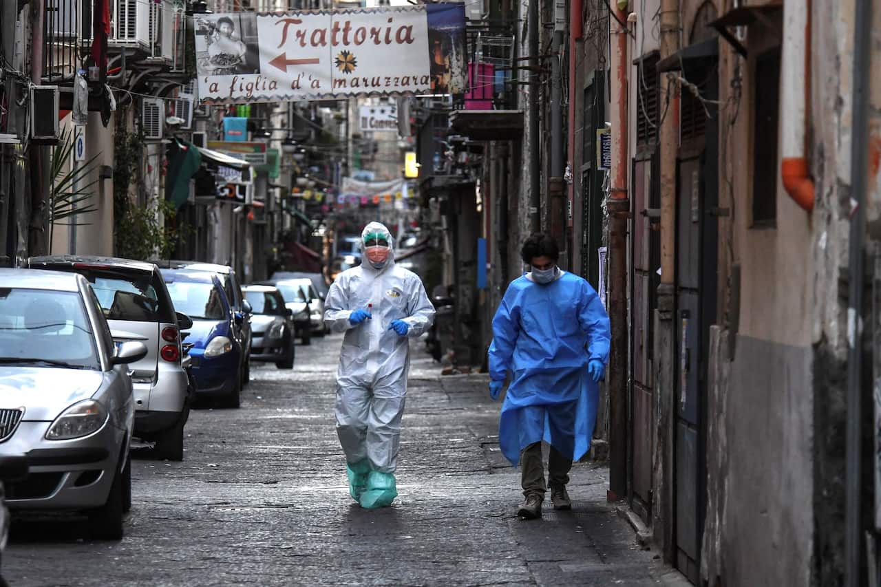 Doctors wear protective clothing as they carry out checks on citizens in Naples, Italy