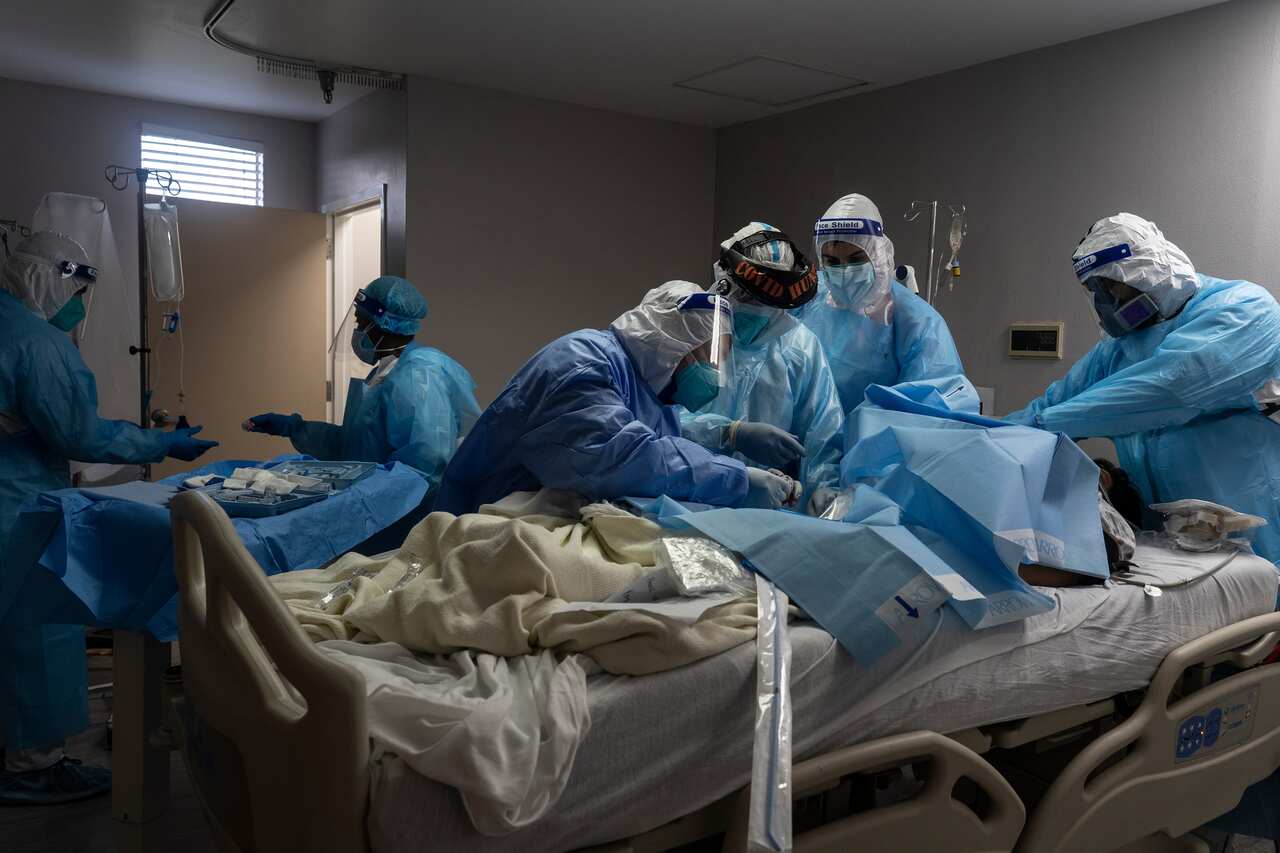Medical staff members treat a patient suffering from coronavirus in the COVID-19 intensive care unit at the United Memorial Medical Center in Houston, Texas.