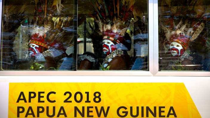 Men in traditional dress ride a shuttle bus ahead of the APEC summit in Papua New Guinea