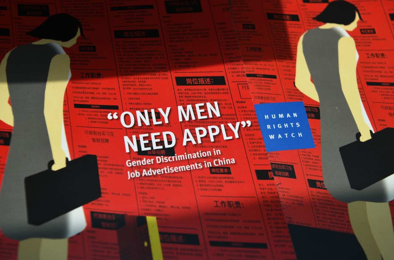 A pile of booklets entitled 'Only Men Need Apply' is displayed during a press conference upon the launch of a new report by Human Rights Watch on discriminatory job advertisements in China