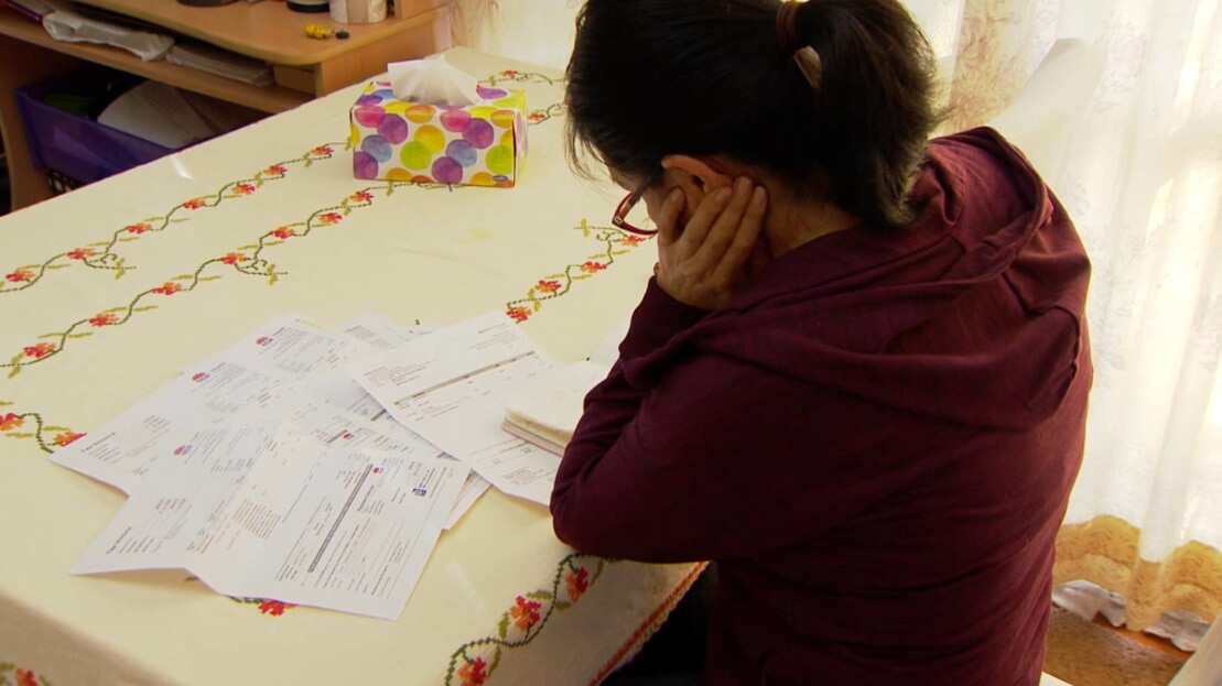 Ines looks at her medical bills