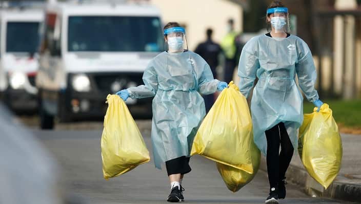 Medical staff with bags of clinical waste is seen at St. Basil's Homes for the Aged in Victoria in Fawkner, Melbourne, Monday, July 27, 2020.