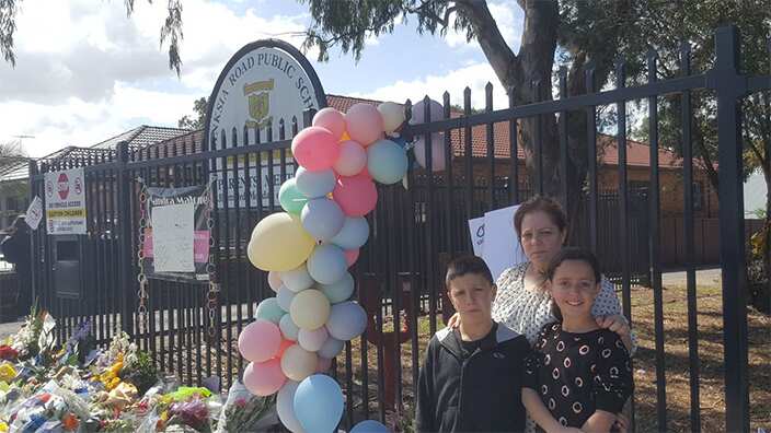 A mother and her children outside the Banksia Road Public School in Greenacre, Sydney