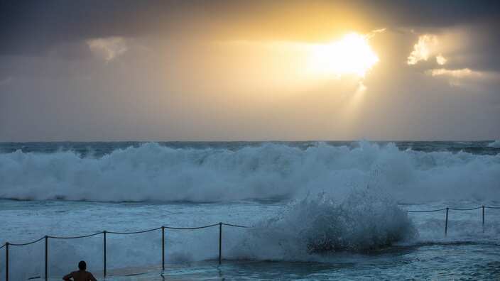 A swimmer looks on as strong winds create choppy seas at the Bronte Beach Ocean Pool in Sydney.