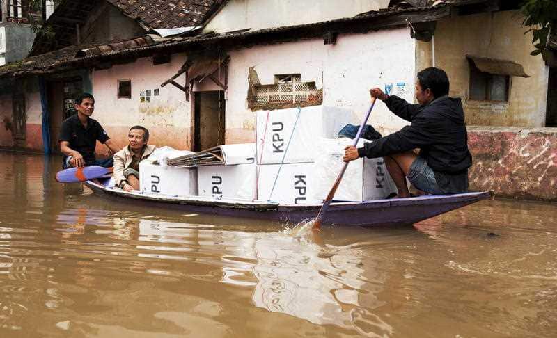 Indonesian election officials transport ballot boxes on a boat in Bandung, West Java, after floods earlier this month.