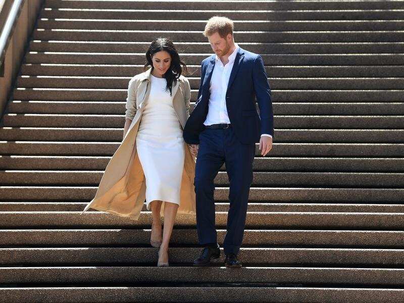 Prince Harry and Meghan descend the steps of the Opera House