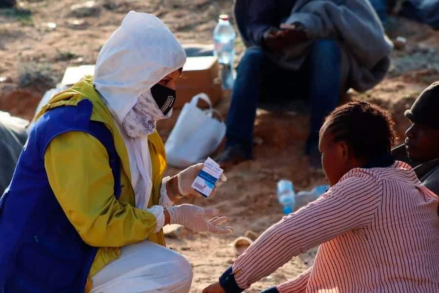 An IOM worker speaks with a survivor from a shipwreck off the coast of Libya near the port of al-Khums.