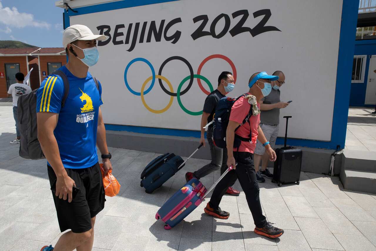 Visitors walk past by the Winter Olympics Beijing 2022 logo in Chongli, in northern China's Hebei Province.