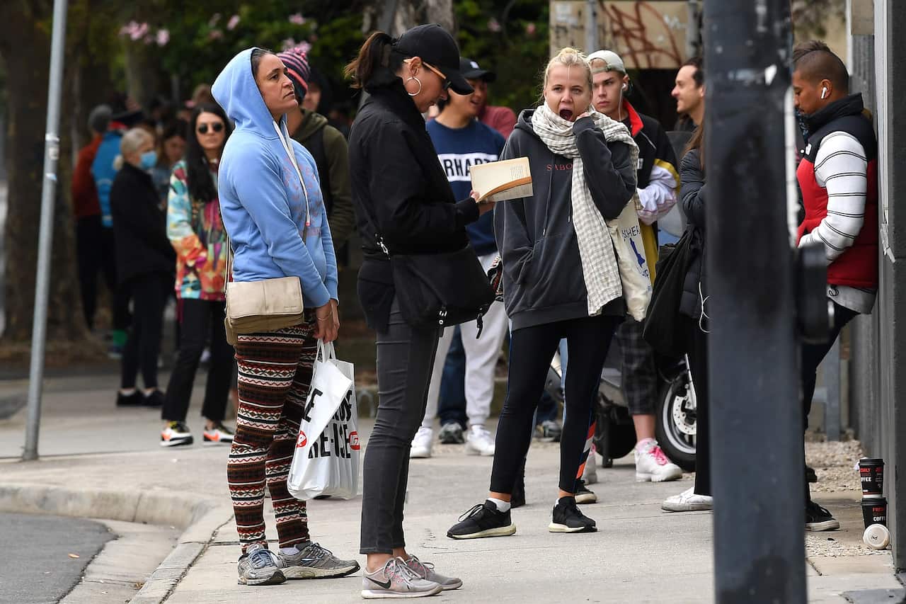 People are seen waiting in line at the Prahran Centrelink office in Melbourne.