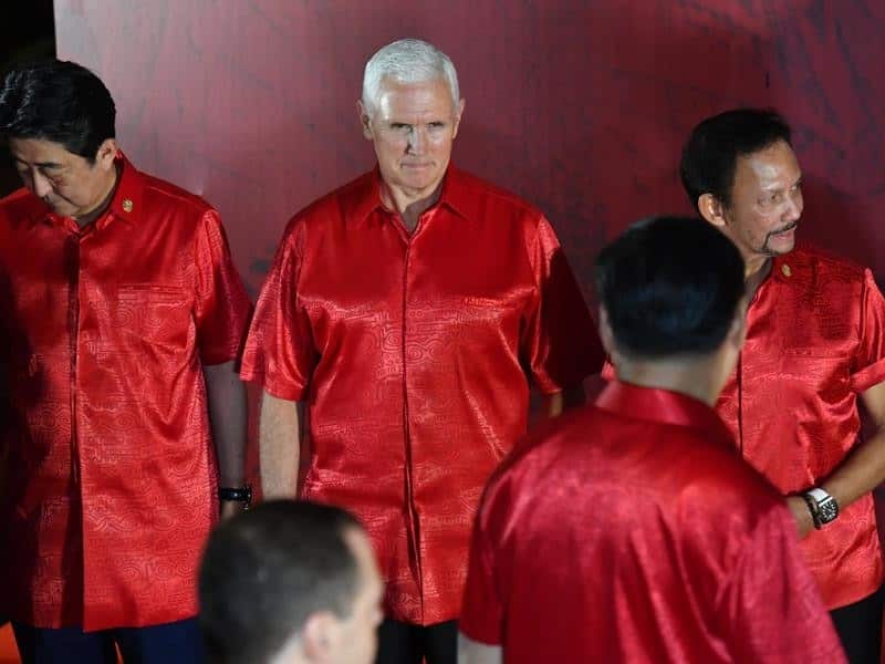 US VP Mike Pence looks at China's President Xi Jinping before the official photograph at APEC summit .