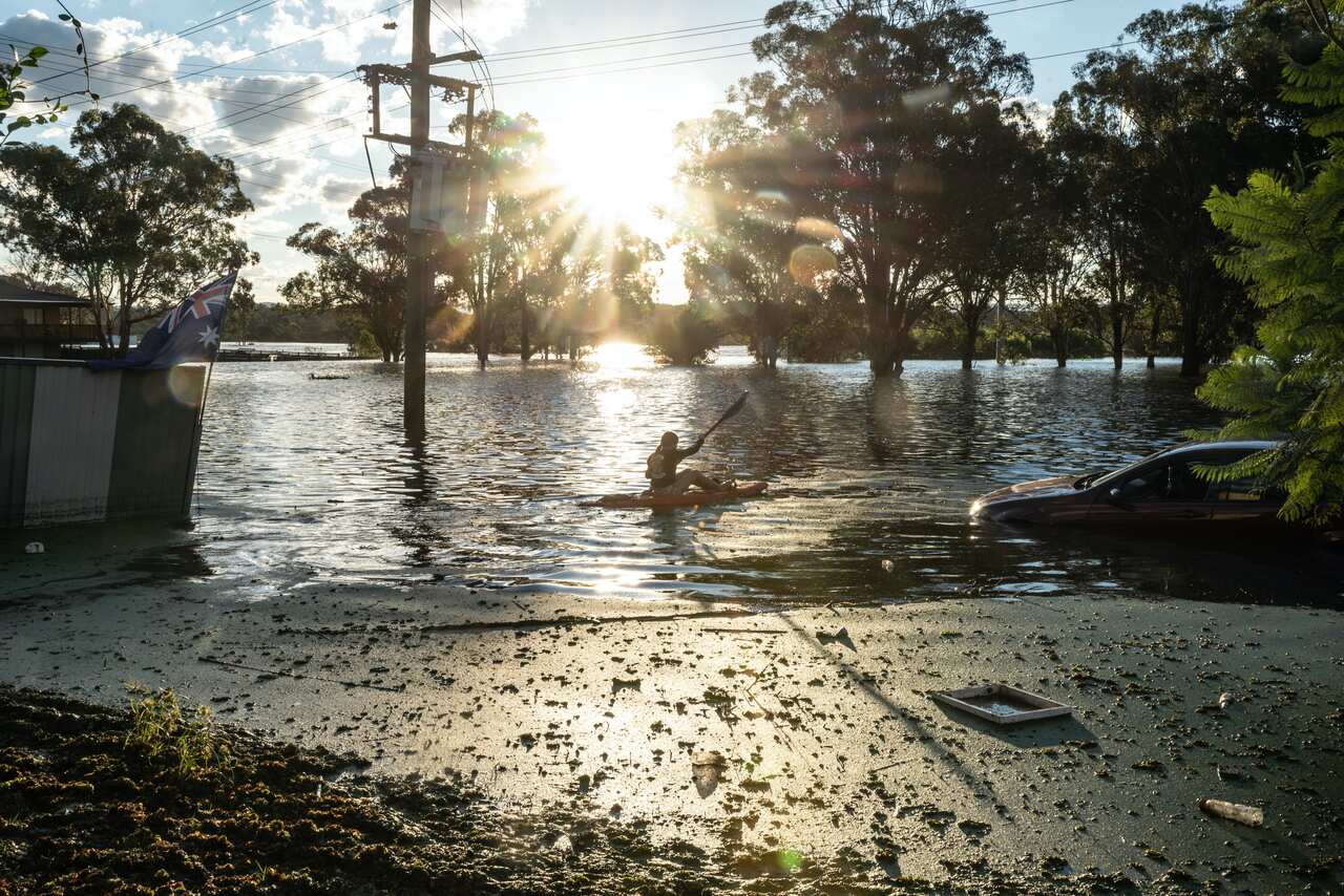 A girl paddles through floodwaters in South Windsor, Sydney, on Wednesday, 24 March.