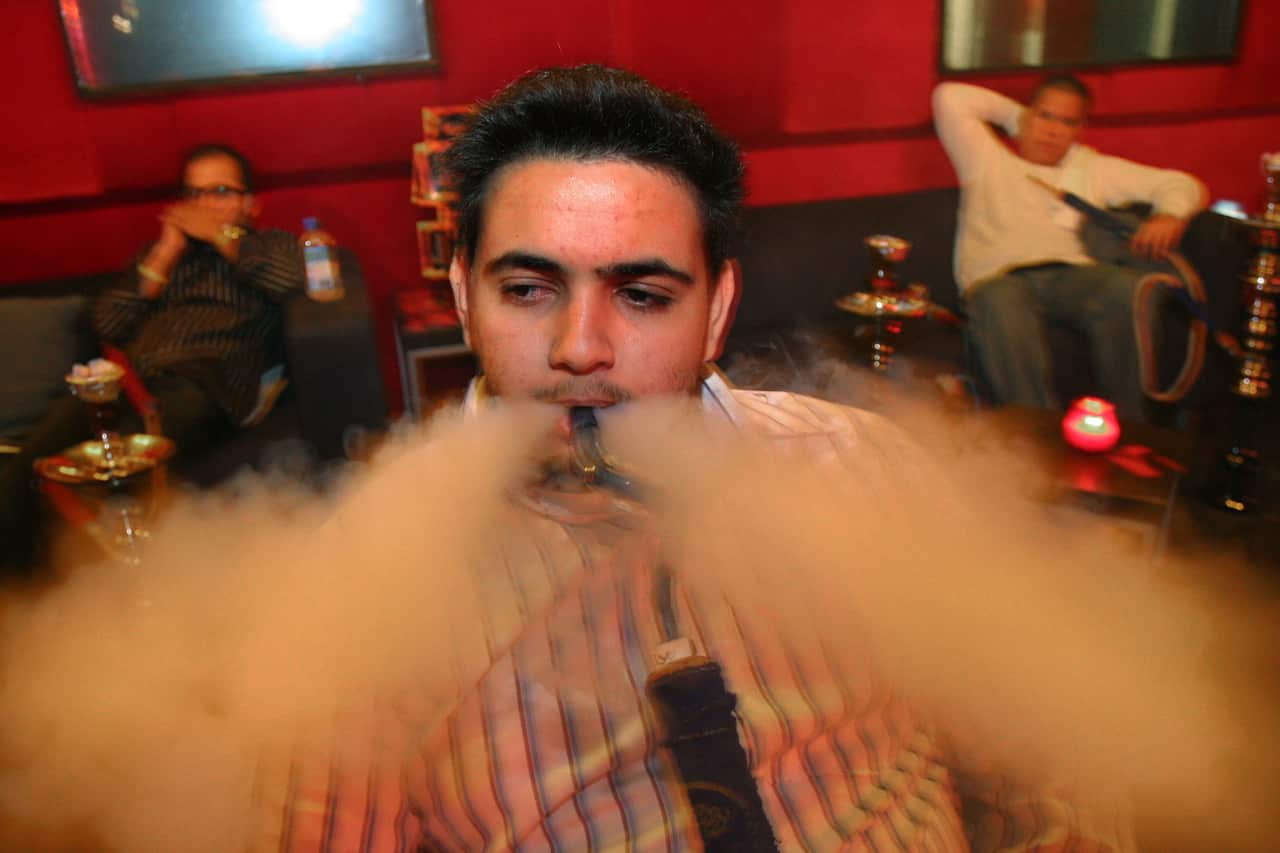 Bilal Sheriff puffs smoke from a hookah pipe at the Fusion Cafe in Anaheim, Calif
