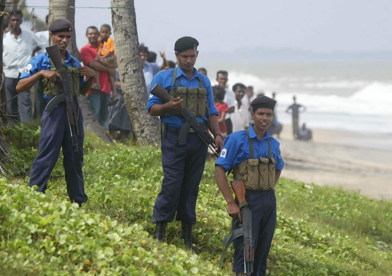 Sri Lankan Navy stand guard where fishermen captured two suspected Tamil Tiger rebels on an apparent suicide mission in Pamunuwa, June 17, 2006. 