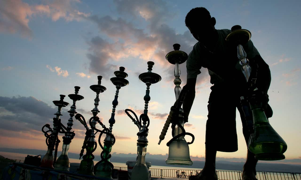 A worker arranges narguile, or water pipes, at a cafe facing the Dead Sea, Jordan, Sunday, Oct. 12, 2008. (AP Photo/Mohammad abu Ghosh)