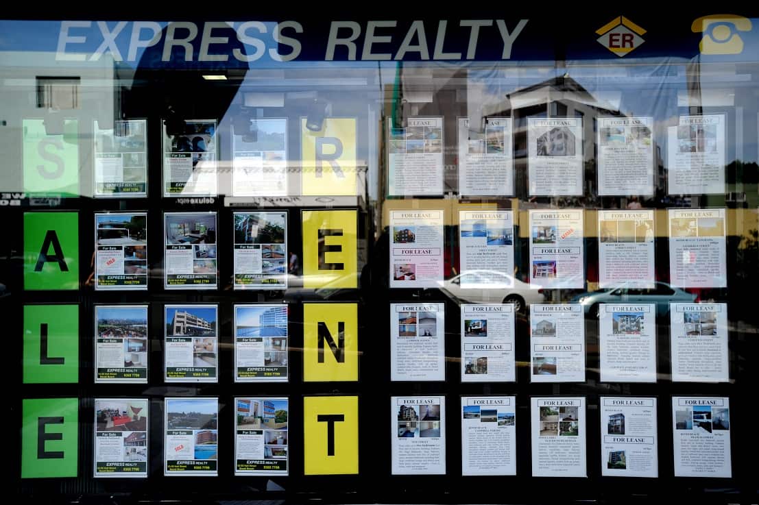 Houses for sale and lease are advertised in the window of a real estate agent at Bondi in Sydney