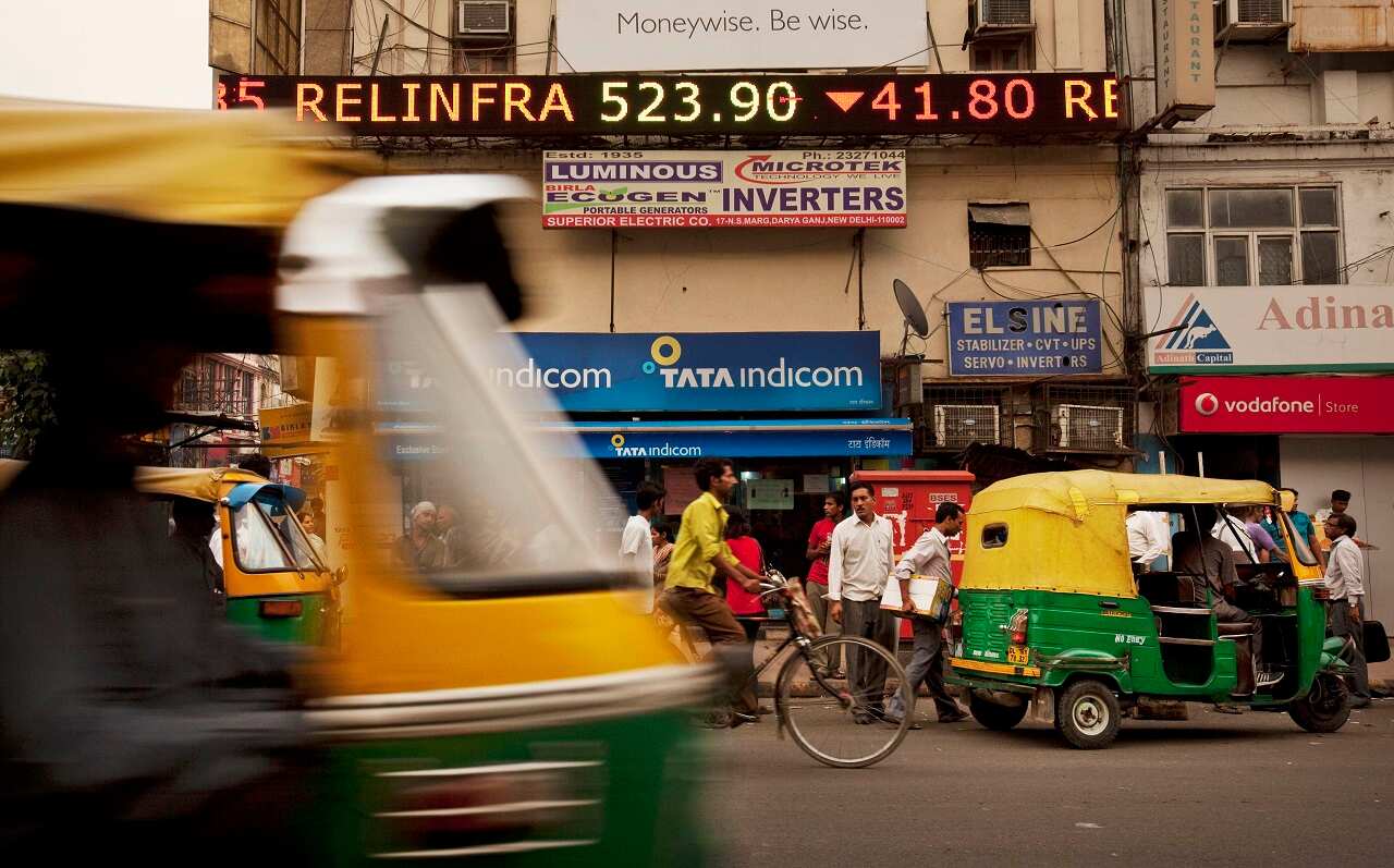 A stock ticker shows a negative trading session for Indian company Reliance as it displays closing figures for the Sensex Index on the Bombay Stock Exchange.
