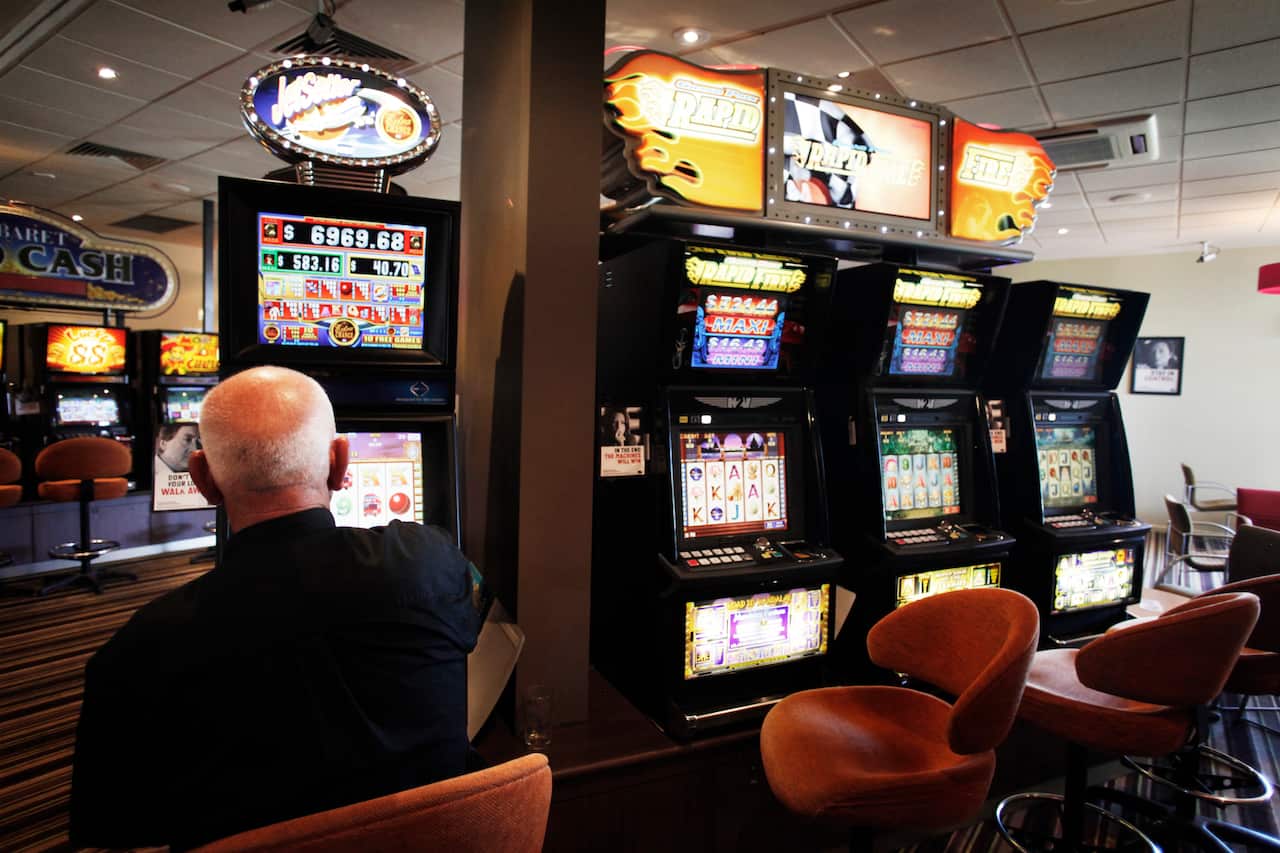 A man plays a pokie machine at a club in Altona, Melbourne on Tuesday, Jan. 24, 2012. (AAP Image/Paul Jeffers) NO ARCHIVING