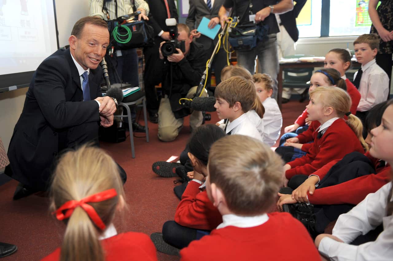 Opposition leader Tony Abbott answers questions from young students learning Chinese during a visit to Brindabella Christian college in Canberra, Wednesday, May 23, 2012. (AAP Image/Alan Porritt) NO ARCHIVING
